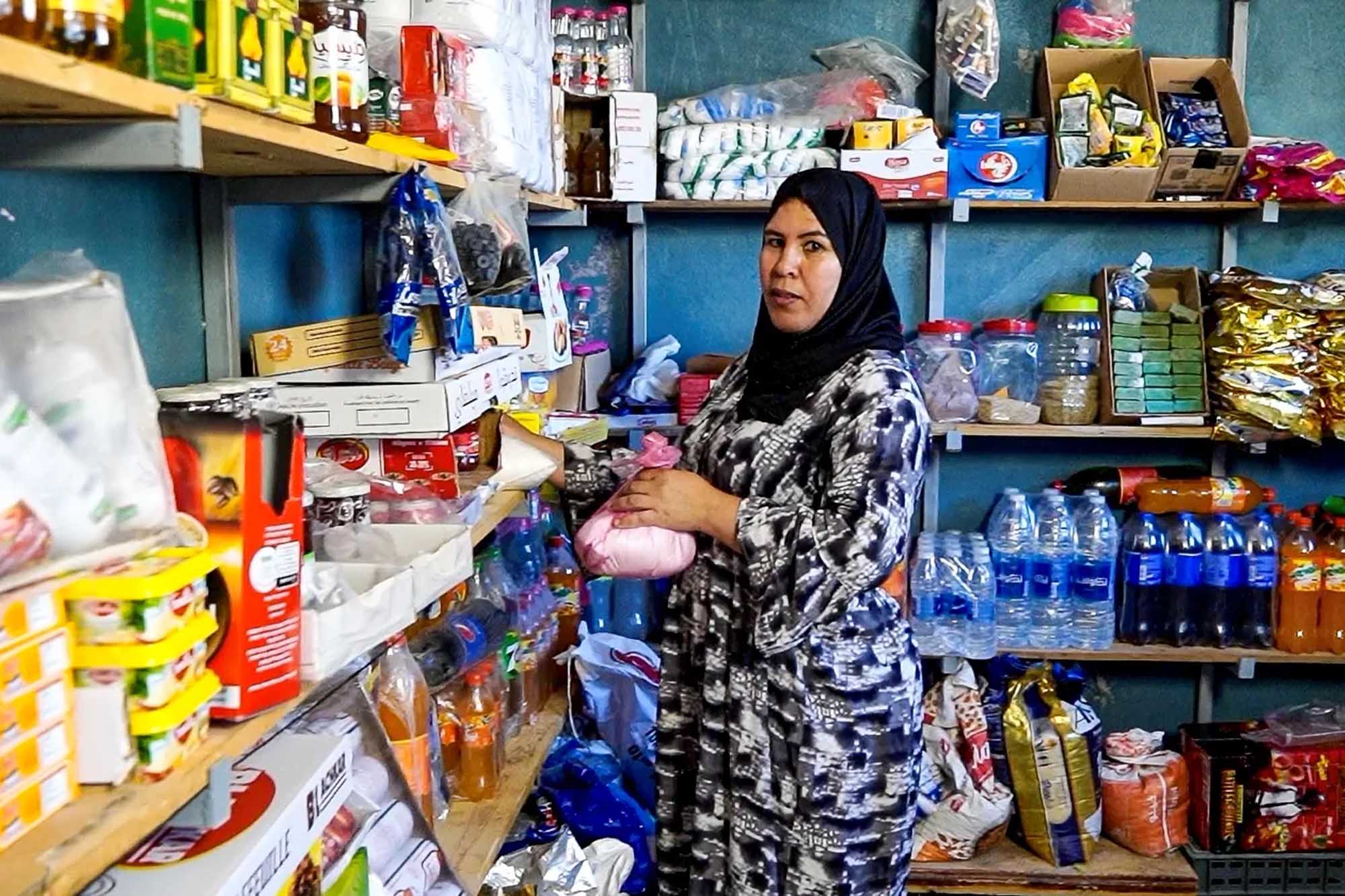 A woman entrepreneur standing inside her grocery store.