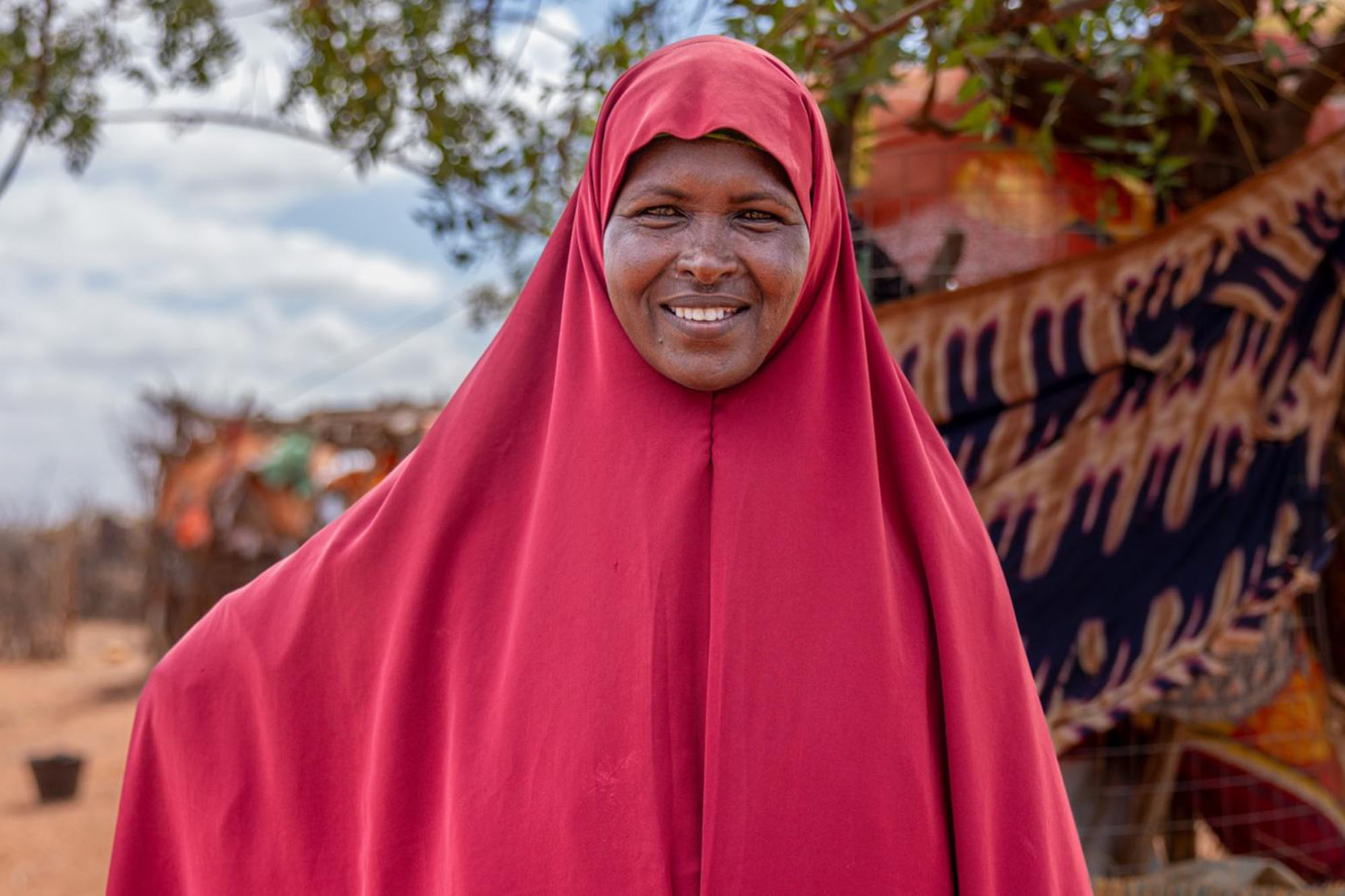 An outdoor scene featuring a woman dressed in a red that covers both their head and body.