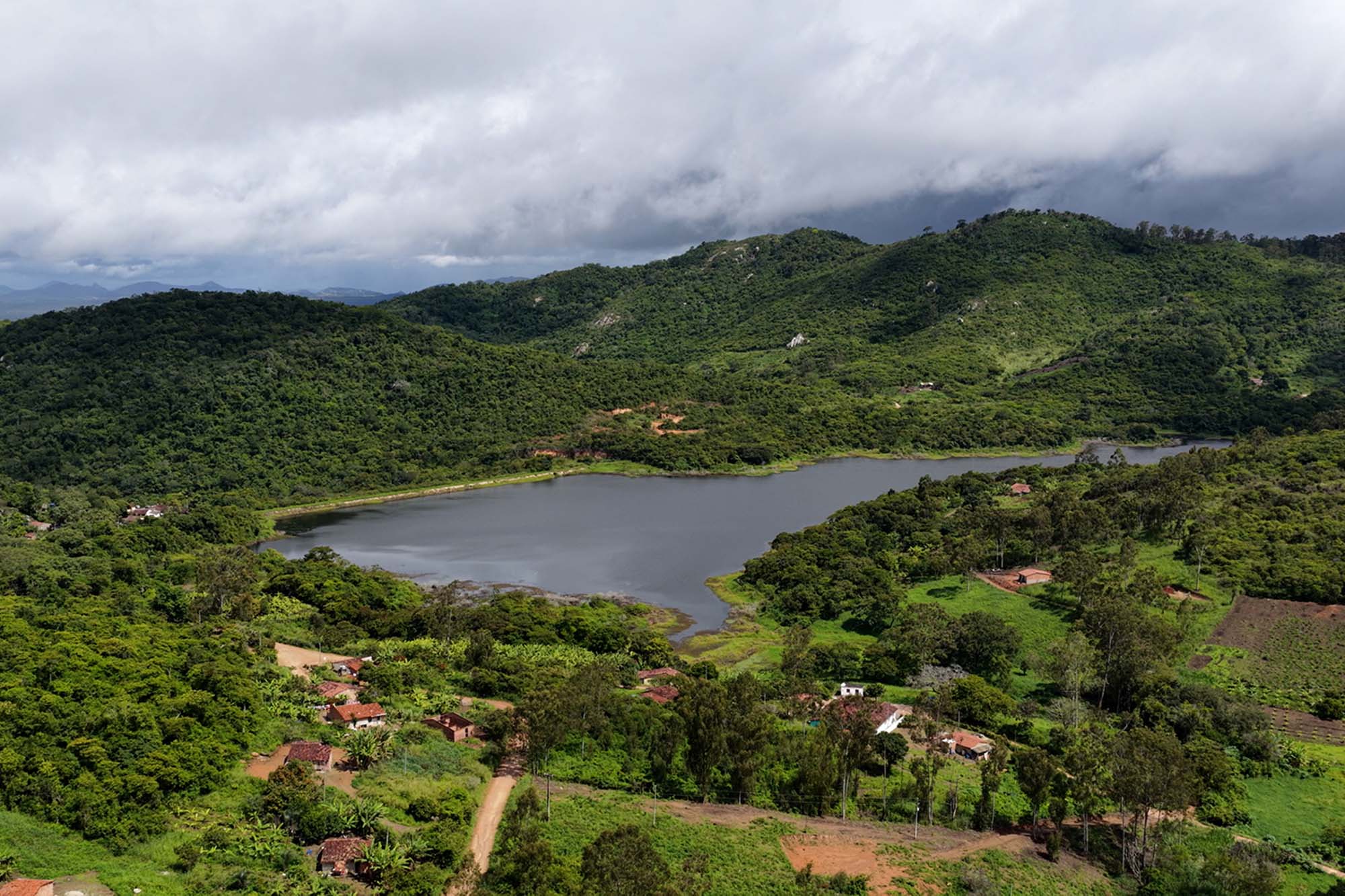 A view of a green landscape dominated by rolling hills covered in dense vegetation of the Ororubá Mountains in Pernambuco, Brazil.