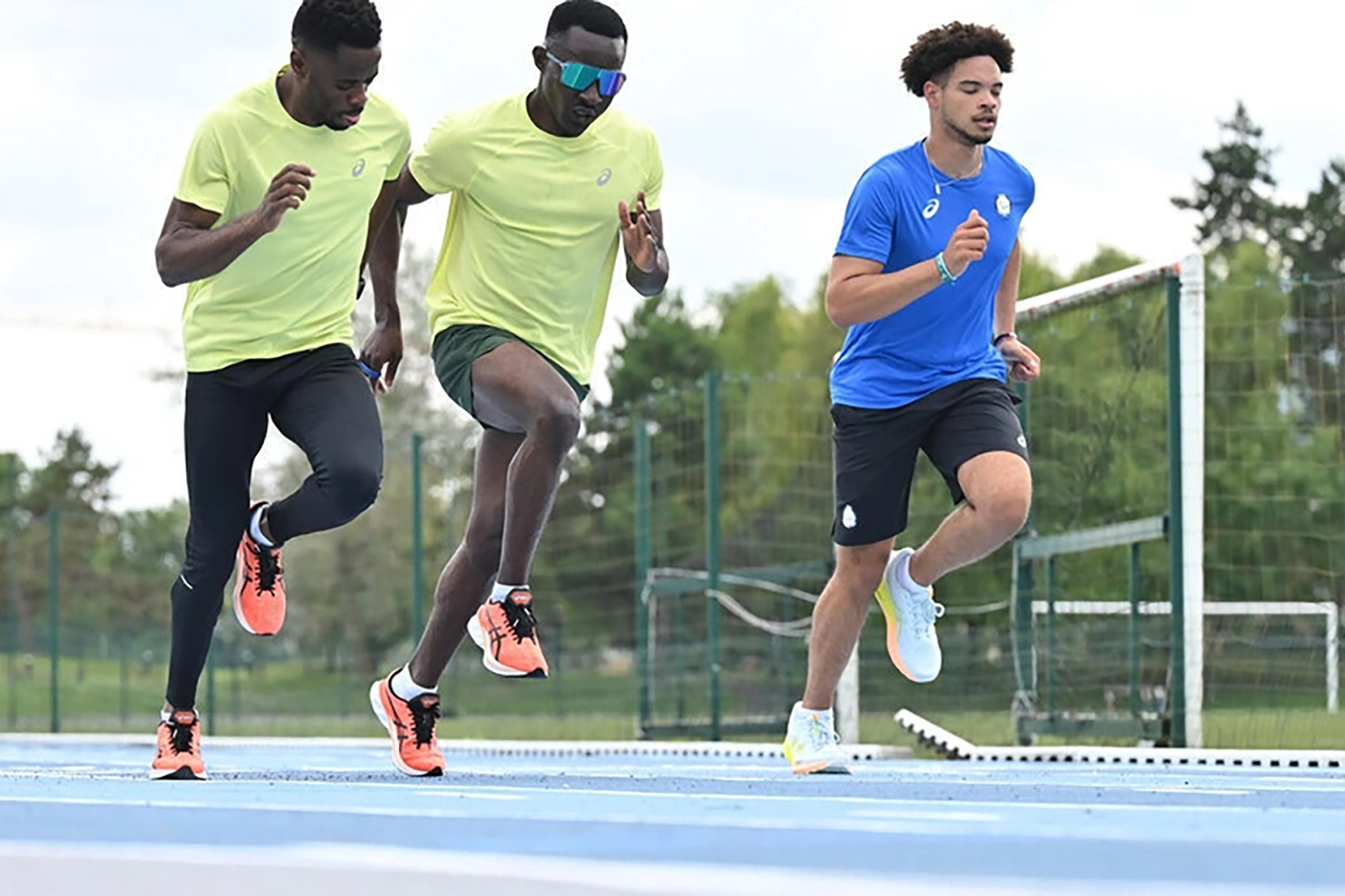 A Paralympic athlete training with two guide runners.