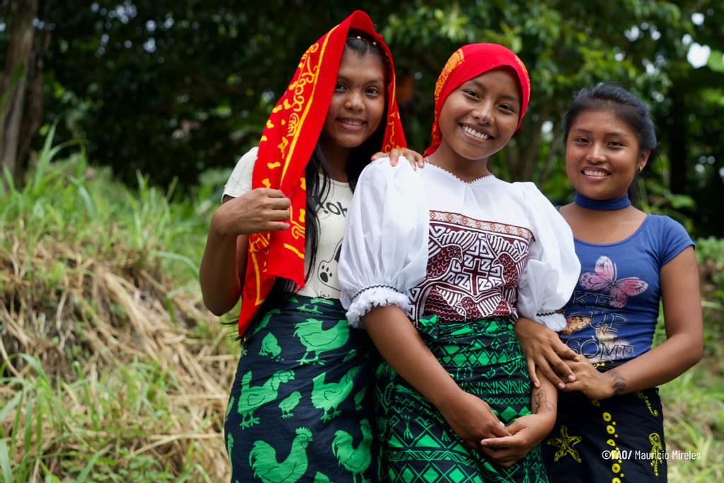 Portrait of three young women smiling at the camera.