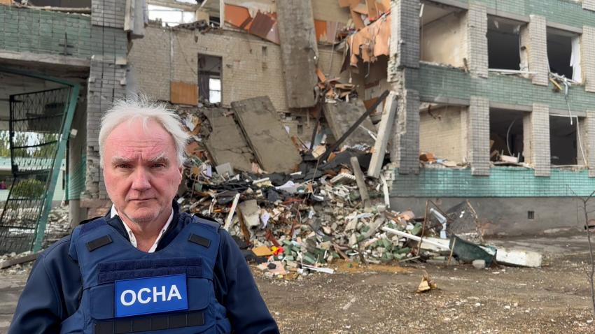 Matthias Schmale in OCHA protective vest in front of destroyed building