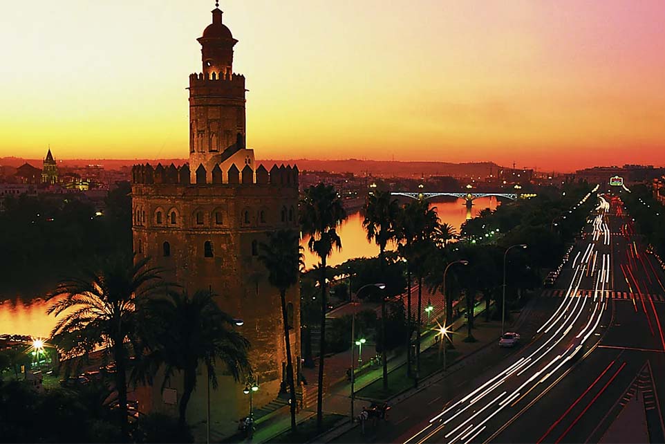 The watchtower “Torre del Oro” in Seville, Spain, on the banks of the Guadalquivir River at sunset