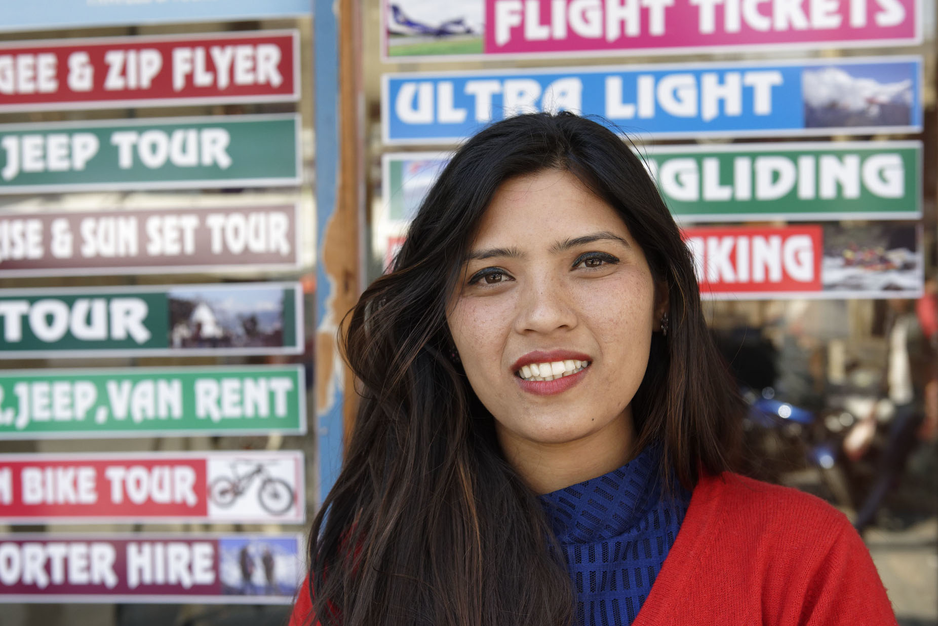 A woman standing infront of a tourism board.