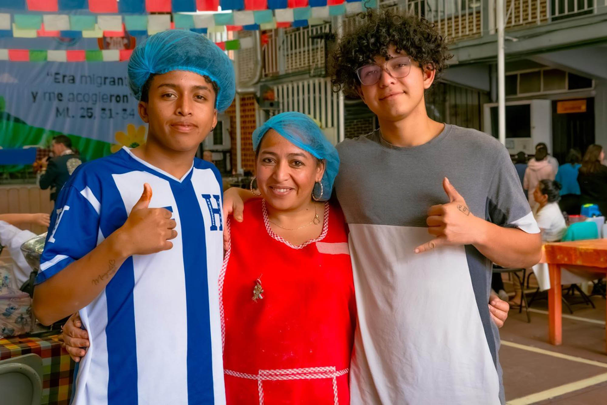 Magaly Yolibeth Chicas, a migrant woman from Honduras, stands close to her sons, with their arms around each other. She works alongside them.