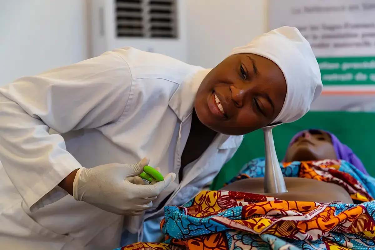 midwife trainee practicing on mannequin