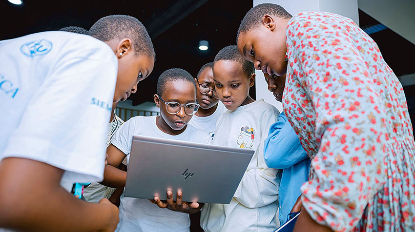 Young female participants work together on a laptop during a Girls Can Code Initiative bootcamp in Rwanda.