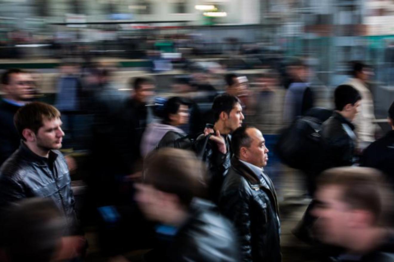 A photograph of blurred figures moving through a metropolitan space