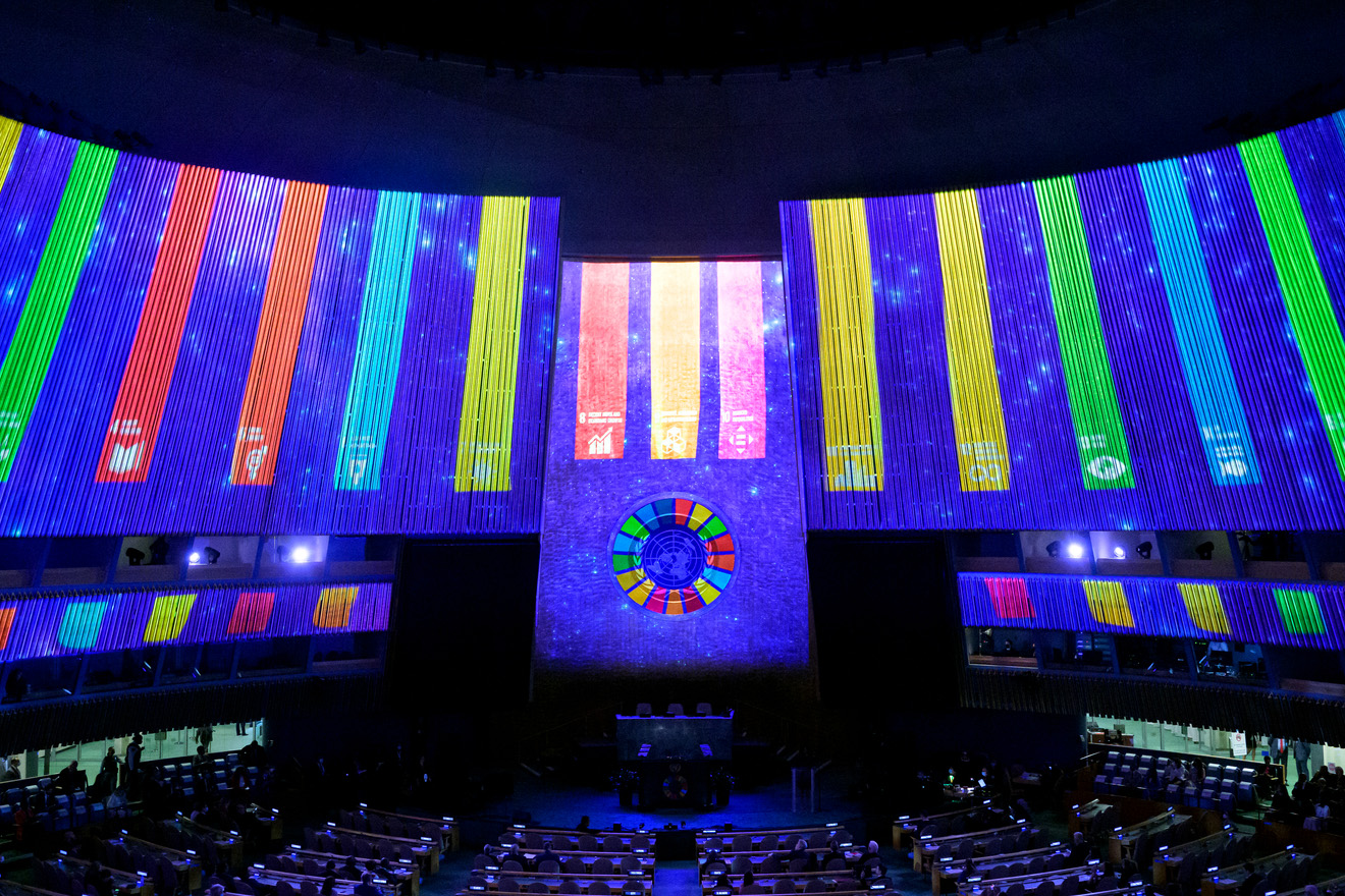 General Assembly hall with the SDG logos and colors projected on its walls.
