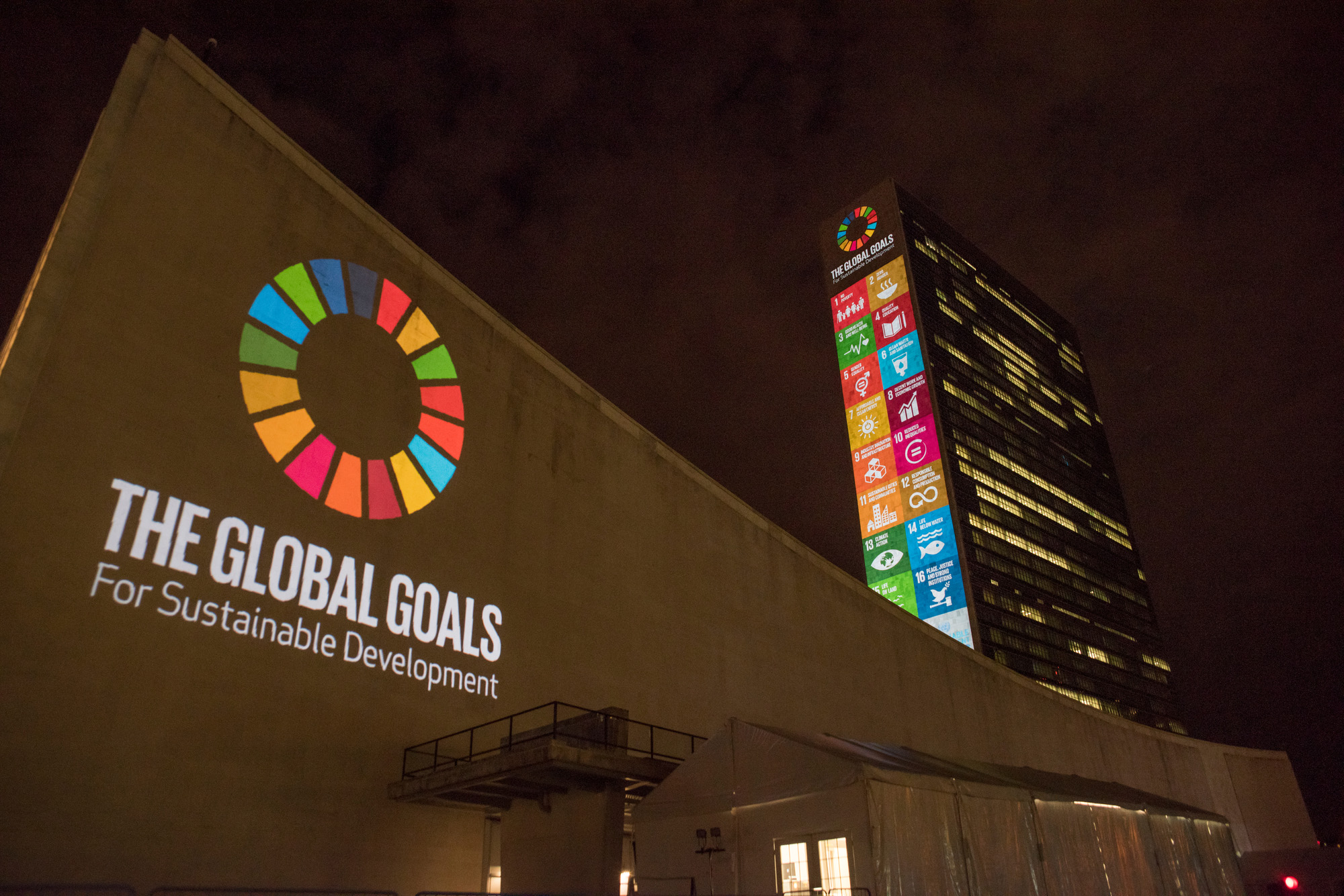 A projection on the UN Secretariat building in New York of the 17 Sustainable Development Goals and their logo.