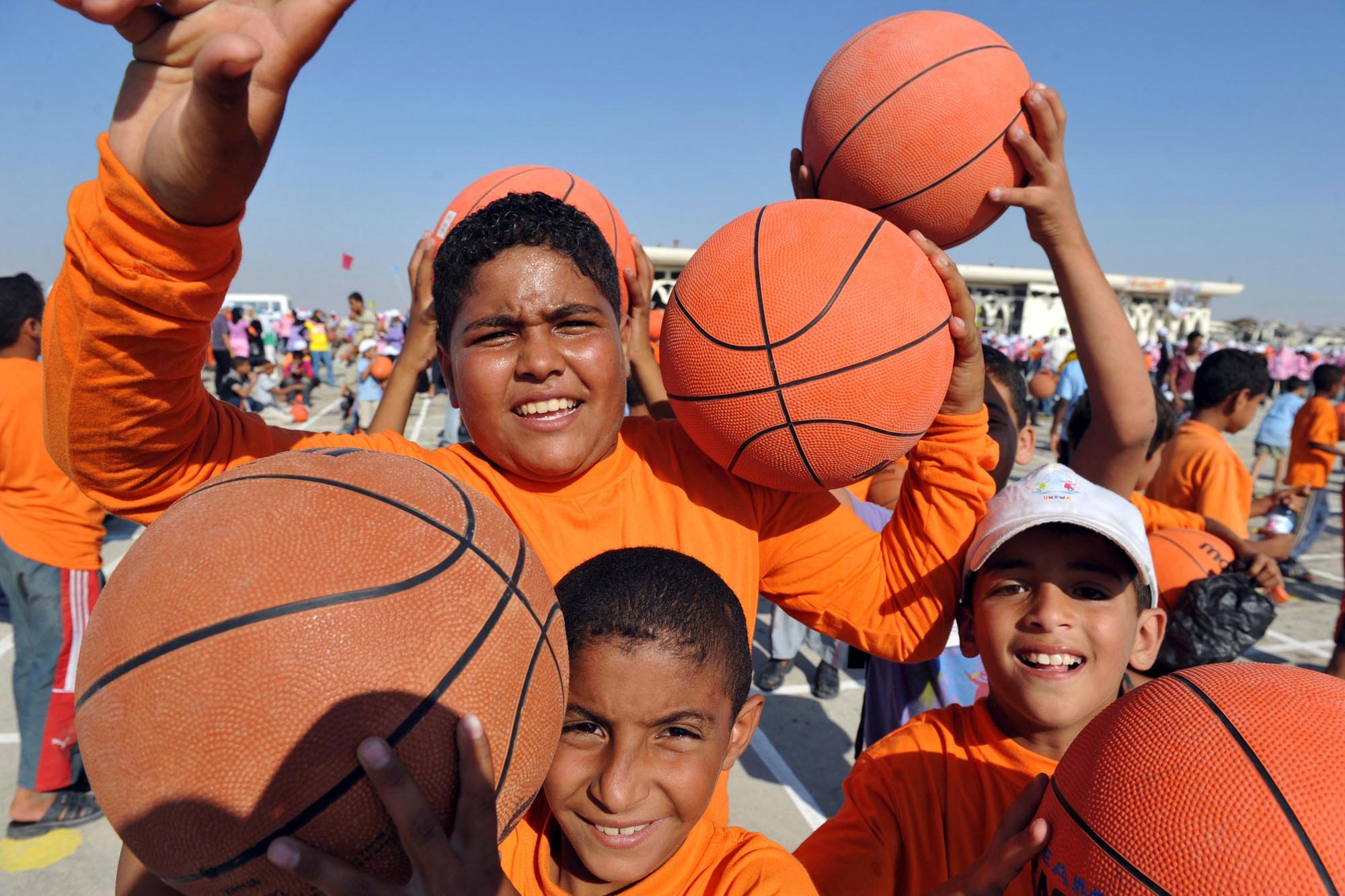 Schoolboys in Gaza holding basketballs.