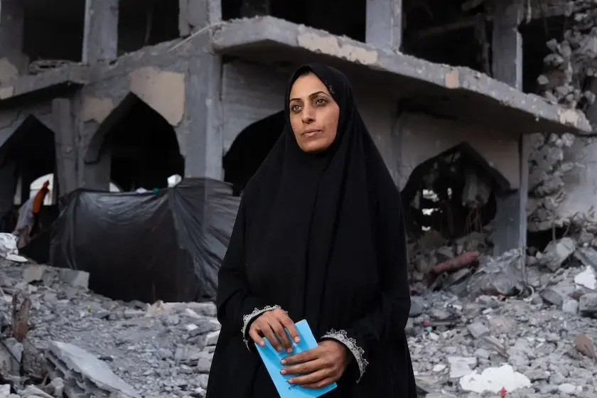 Riman standing in front of a ruined building.