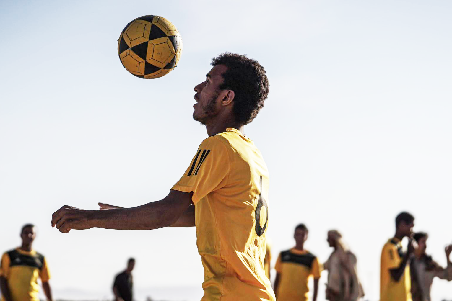 A man kicking a football in the air.