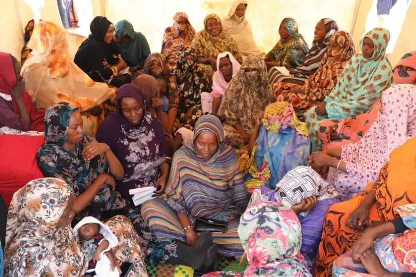 A group of women with their babies huddled together.